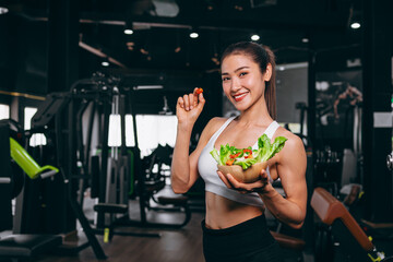 Healthy women in Fitness Gym Body Care by Eating Vegetable and weight Training in Sport Club.