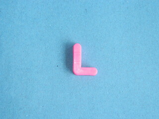 Macro photo or closeup photo of the alphabet from children's toys on a blue background. Use on...