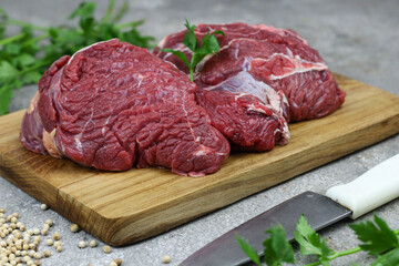 Daging sapi mentah or raw beef on preparation for cooking with some spice. Beef on Eco friendly package and chopping board with wooden rustic background.