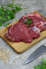 Daging sapi mentah or raw beef on preparation for cooking with some spice. Beef on Eco friendly package and chopping board with wooden rustic background.