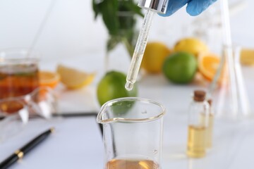 Aromatherapy product. Scientist developing essential oils at white table in laboratory, closeup
