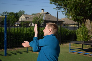 A focused young athlete dynamically performing warm-up drills and stretches outdoors. Clad in...