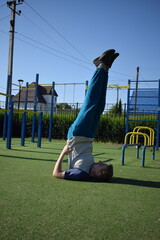 A focused young athlete dynamically performing warm-up drills and stretches outdoors. Clad in...