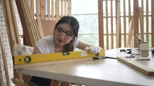 Carpenter is working at woodshop.