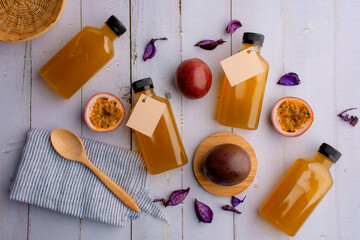 Fresh passion fruit juice in glass with passion fruits on wood background.