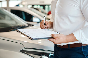 Car dealership, hands or salesman with documents for vehicle, finance checklist or loan paperwork....
