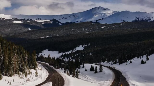 i70 highway Vail Pass Colorado aerial drone cars trucks sky chutes Copper Mountain ski resort trail runs ten mile range Ikon snowy winter spring snowy peaks clouds sunset golden hour upward motion