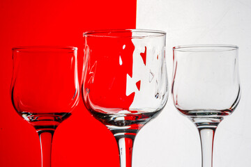 Three empty wine glasses with a red and white striped background.
