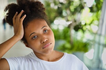 Disappointed Young black African woman in casual style holding her head or temple, having headache,...
