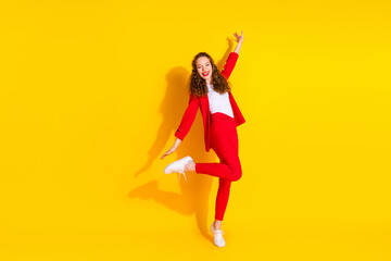 Full body portrait of gorgeous young lady dancing wear red suit isolated on yellow color background