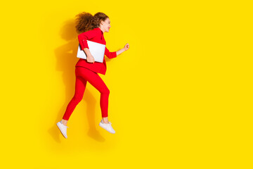 Fototapeta na wymiar Full body portrait of gorgeous young lady laptop jump run empty space wear red suit isolated on yellow color background