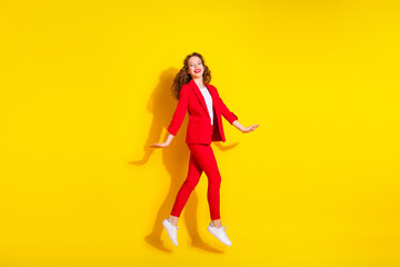 Fototapeta na wymiar Full body portrait of gorgeous young lady jump empty space wear red suit isolated on yellow color background