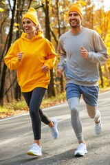 Obraz premium Happy young couple jogging in autumn park, with room for text in scenic natural surroundings