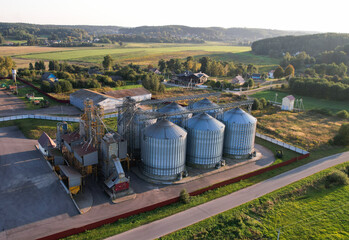 Grain storage Silo at farm, drone view. Wheat flour mill. Elevator for corn storage and grain. Feed Silos Hopper for wheat storage, barley. Wheat flour plant. Grain drying in Steel Silo, aerial view.