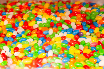 Background from a pile of oval candies in multi-colored glaze.