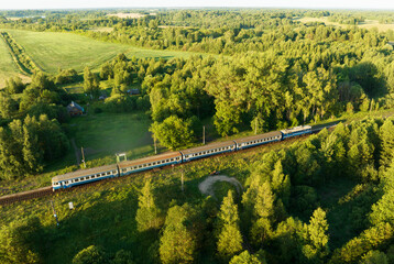 Train at railway station, aerial view. Train on regional railway. Traveling on Passenger train on railway, aerial view. Train with passenger cars rides. Drone view of an passenger locomotive. © MaxSafaniuk