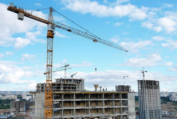  onstruction site with tower cranes on building construction. Builder on formworks. Cranes on pouring concrete in formwork. Tower cranes on construction in built environment. Buildings renovation.