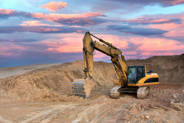 Excavator on sunset background. Open-pit mining. Backhoe dig ground in quarry. Heavy construction...