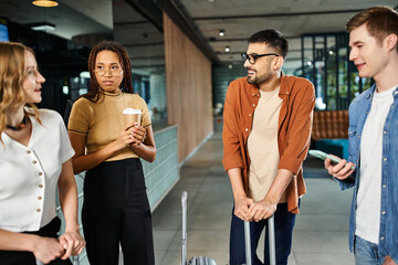 Diverse businesspeople in casual attire standing in a circle, discussing in a hotel lobby during a corporate trip.