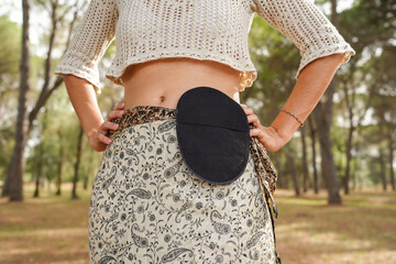woman showing her abdomen and a ostomy bag outside. Cancer Concept.