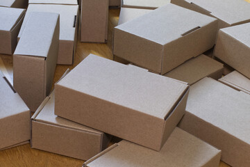 Identical in size paper boxes scattered on a wooden floor, an ecological way of packaging, an...