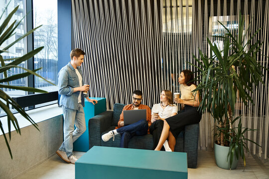 A diverse group of colleagues in a modern coworking space, sitting on stylish couches, engaged in a lively discussion.