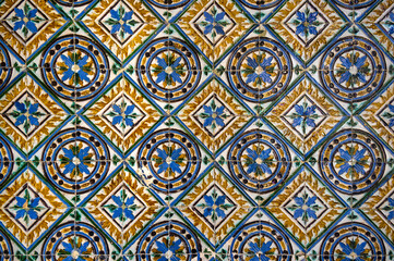 Background made from a piece of antique colored tiles with a geometric and floral pattern