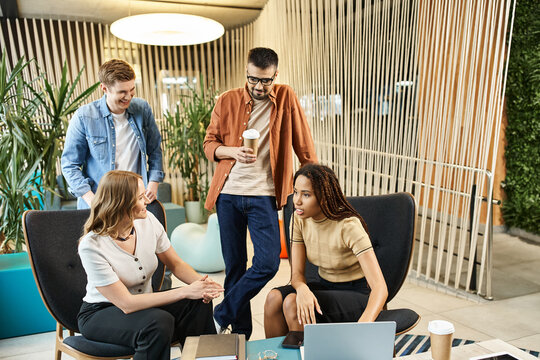 A diverse group of colleagues seated around a table, laptops open, engaged in a collaborative discussion on modern business strategies.