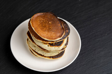 soft fresh pancakes and natural liquid honey in a wooden bowl