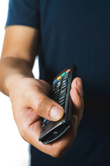 Fototapeta premium A man's holds and presses the button of an broken and old TV remote, isolated on white background