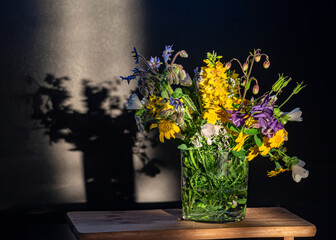 Still life with bouquets of colorful summer flowers, quiet shadows in the background, soft evening...