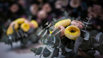 Dark flower background soft focus on colourful buds of flowers in yellow and rose ranunculus and eucalyptus bouquet close up high quality photo