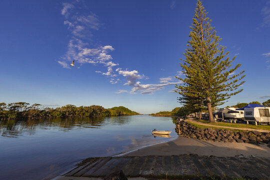 Lone tinny moored on the Brunswick river beside caravan park
