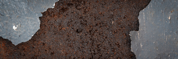 Texture of rusty metal with peeling enamel. Rough surface of painted metal with rust. Corroded and oxidized old iron. Rusted metal. Wide panoramic texture for background and design in grunge style.