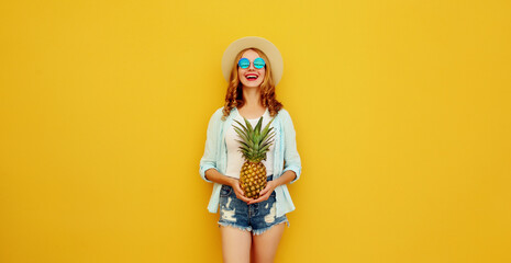 Summer vacation, happy joyful young woman with pineapple fruit, cheerful girl on yellow background
