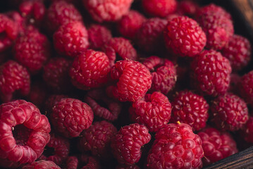 Ripe raspberries in a wooden bowl
