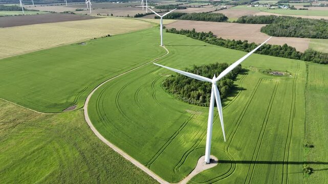 Aerial view of a vast, picturesque farmland with a windmill in Mapleton, Ontario, Canada