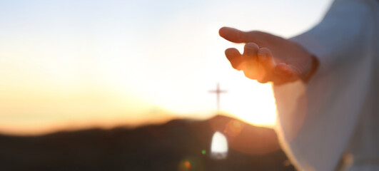 Hands of Jesus resurrected from the tomb and bright light background, heaven and cross love and salvation concept
