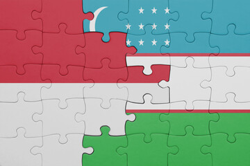 Fototapeta premium puzzle with the colourful national flag of uzbekistan and flag of indonesia.