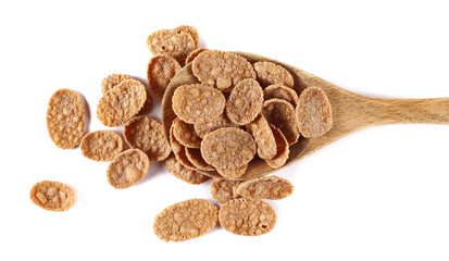 Branflakes pile, fiber flakes in wooden spoon isolated on white, top view