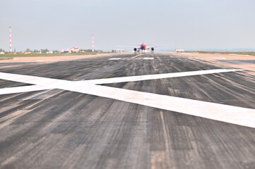 A white cross on an airport runway prohibits landing of airliners due to repairs. Close-up view of...