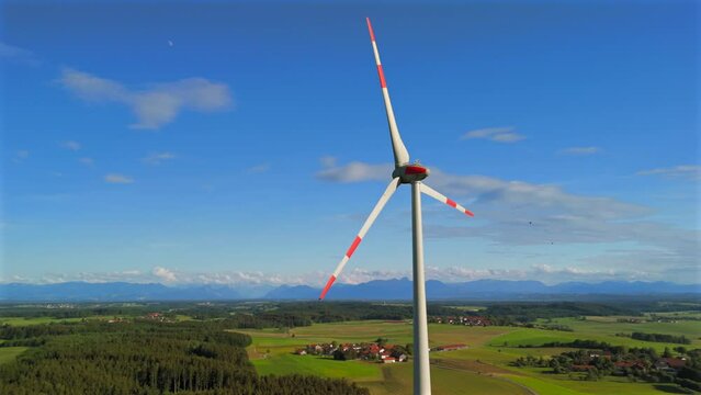 Aerial view of wind turbine in Bavaria, Ebersberg region, Germany. Luftaufnahme einer Windturbine vor dem Hintergrund der Alpen in Bayern, Deutschland. Wind turbine on golf course overlooking alps. 