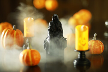 Spooky Halloween Display with Grim Reaper Figurine, Pumpkins, and Foggy Candles