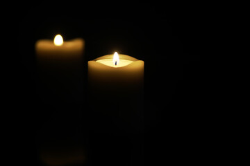 Serene Candlelight in Darkness - Two Burning Candles Isolated on Black Background