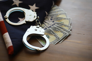 Handcuffs on American Flag with Dollar Bills - Law Enforcement, Crime, Corruption Concept