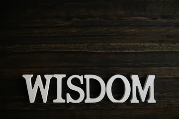 Wisdom Word on Dark Wooden Background for Inspirational and Motivational Themes