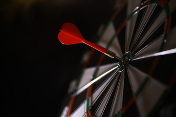 Red Dart Hitting the Bullseye on Dartboard - Precision, Success, and Target Achievement Concept