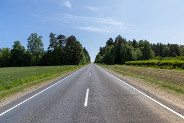 a narrow paved road in the summer