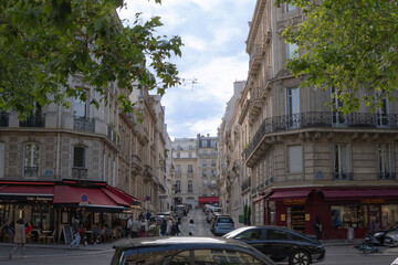 Busy street in Paris, France. Two crowded small restaurants on a busy street.