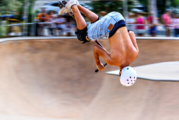 Fototapeta premium Young man practicing Scootering (Freestyle Scootering) in the new SkatePark in the central park of Igualada, Barcelona, blurred background